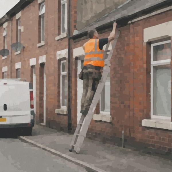 A repairs operative on a ladder outside a row of terraced homes