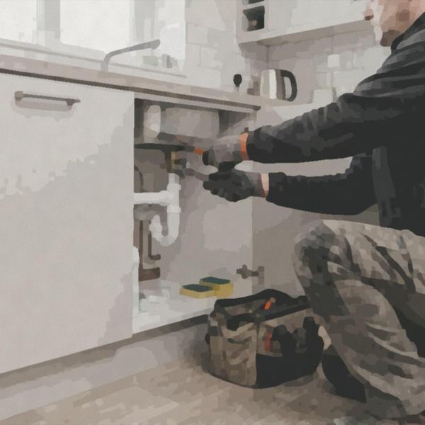 A repairs operative fixing the pipes under a kitchen sink